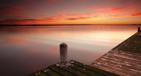 Glorious red sunrise skies and water reflections from one of the jetties at Berkeley Vale on the Central Coast of NSW Australia
